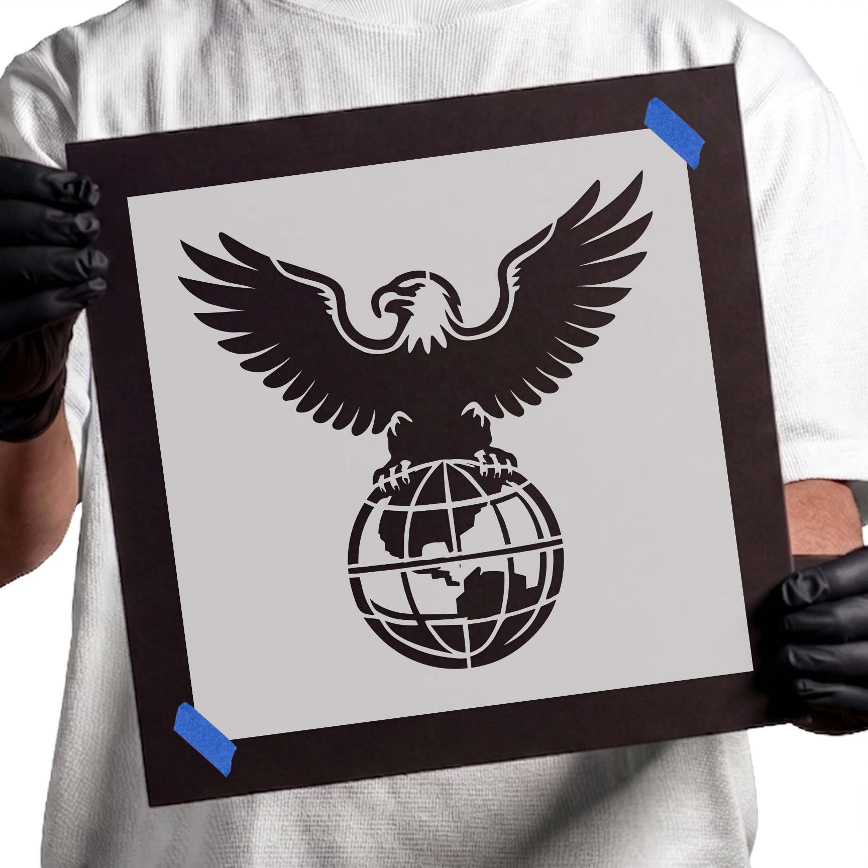 Bald eagle with spread wings perched on a globe stencil