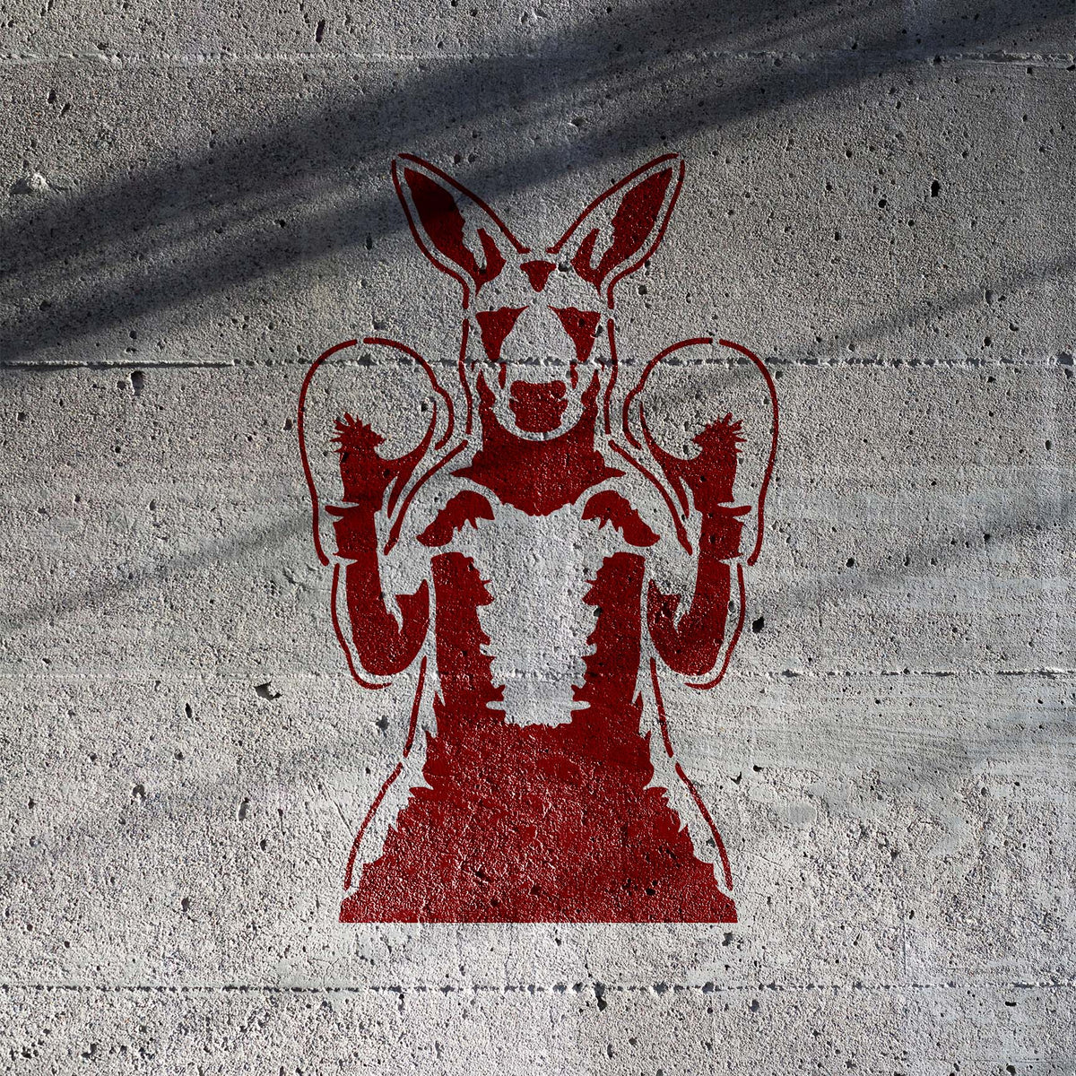 Boxing Kangaroo Stencil painted in red on textured concrete wall