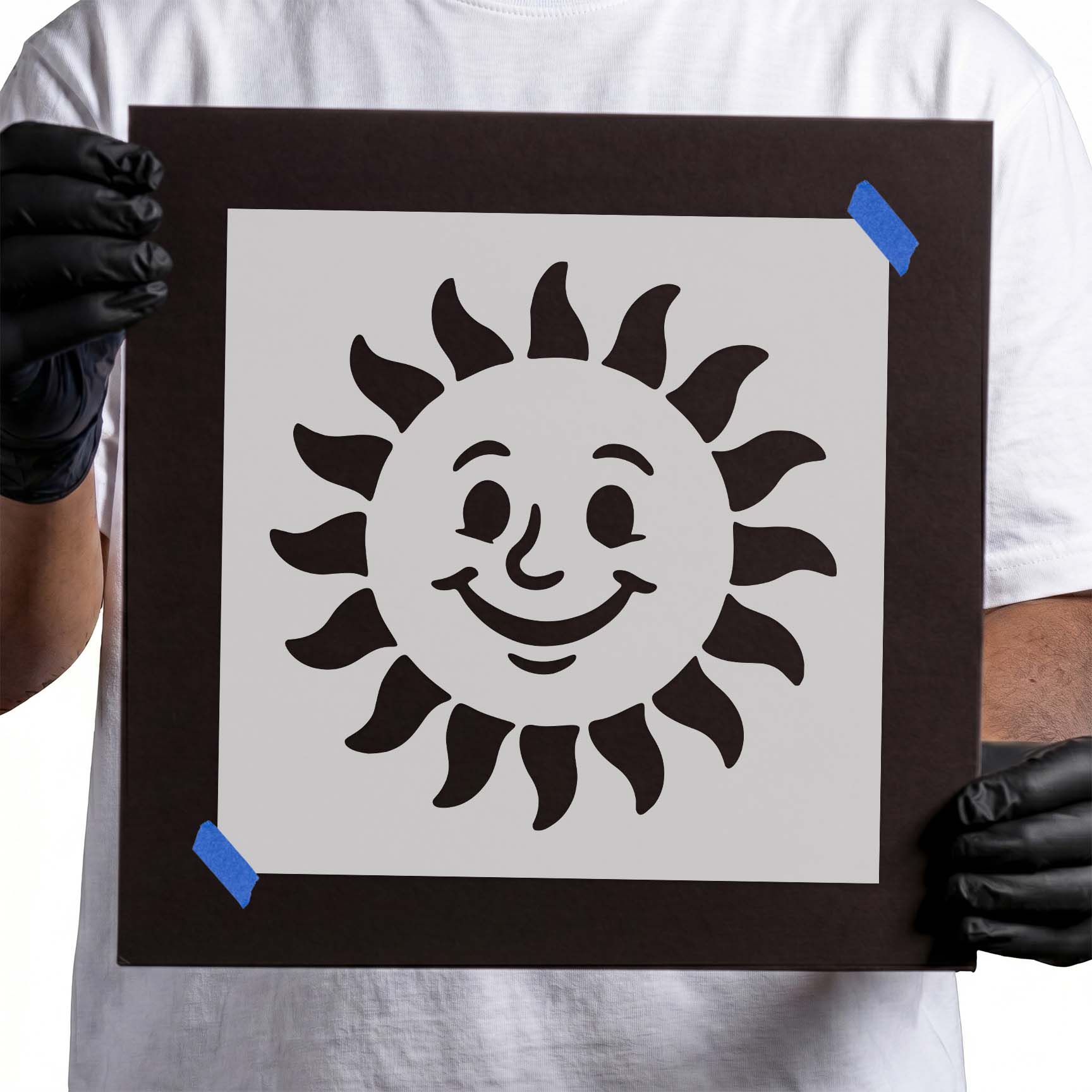 Person holding Cheerful Smiling Sun Face Stencil taped to cardboard