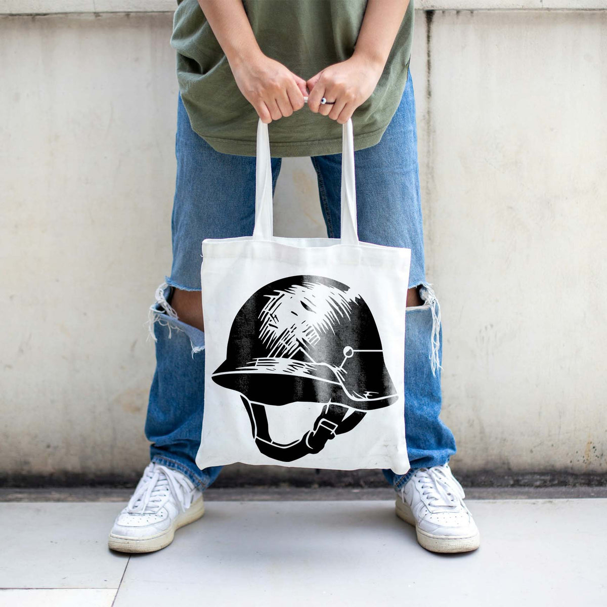 A white tote bag showcases the Classic Military Helmet Stencil in black.
