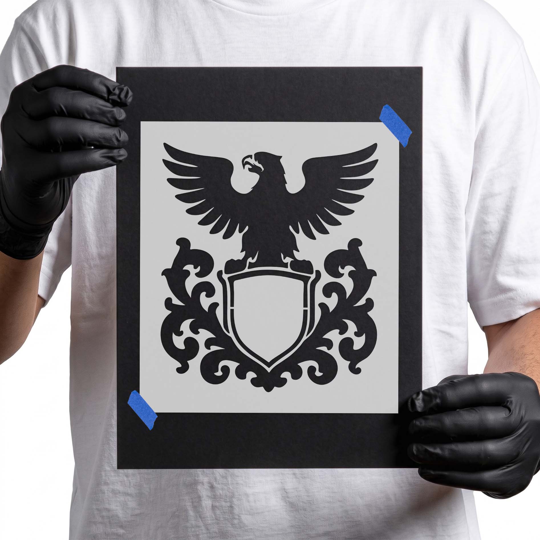 Heraldic eagle stencil above blank shield with decorative scrollwork