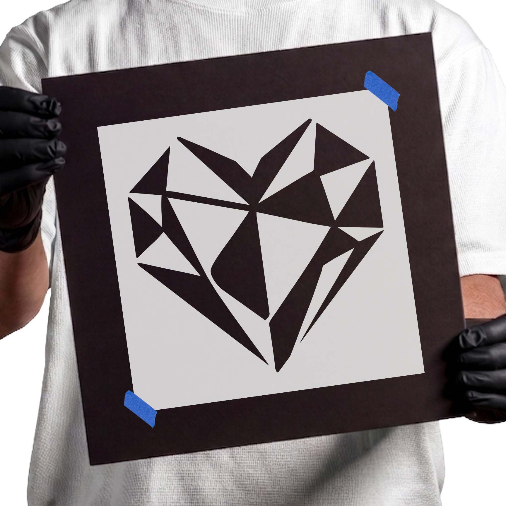 Person holding Modern Geometric Heart Stencil taped to cardboard