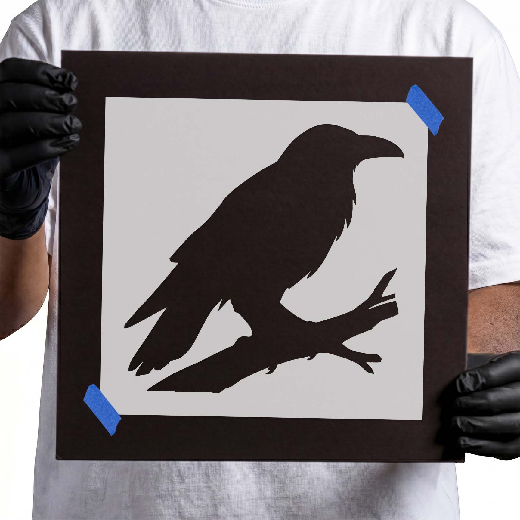 Raven perched on a tree branch in a bold silhouette