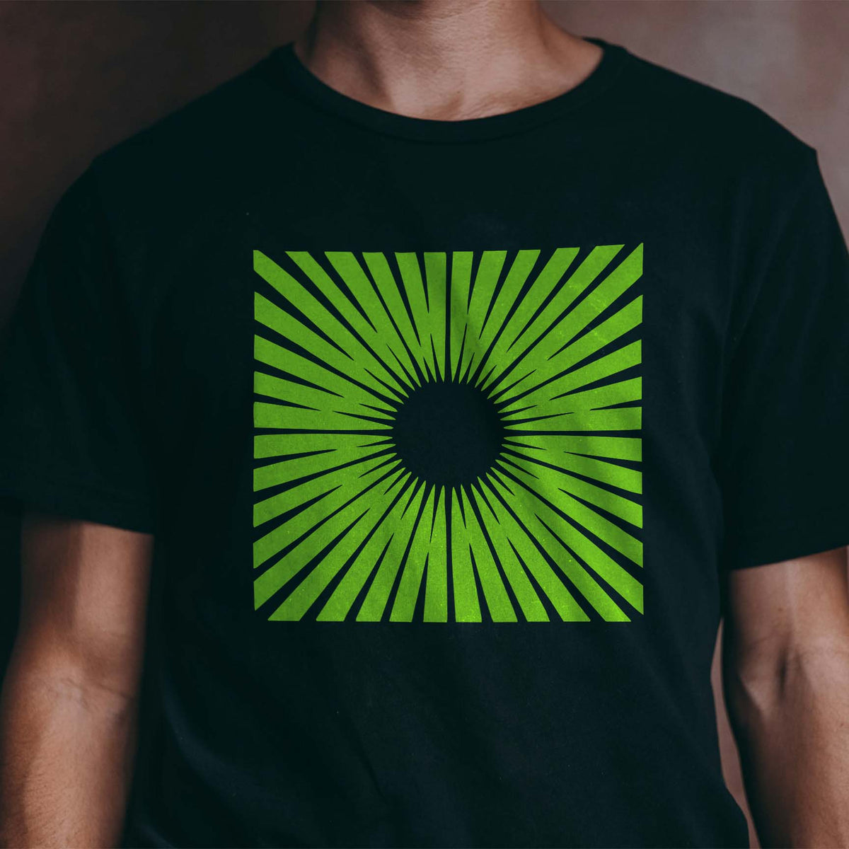 Lime Radiant Sunburst Stencil spreads sharp geometric rays across a black T-shirt