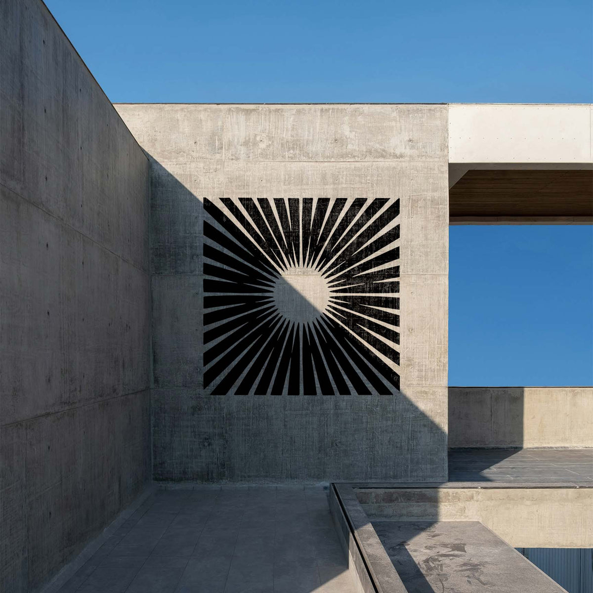 Bold Radiant Sunburst Stencil forms dramatic black rays on a modern concrete wall