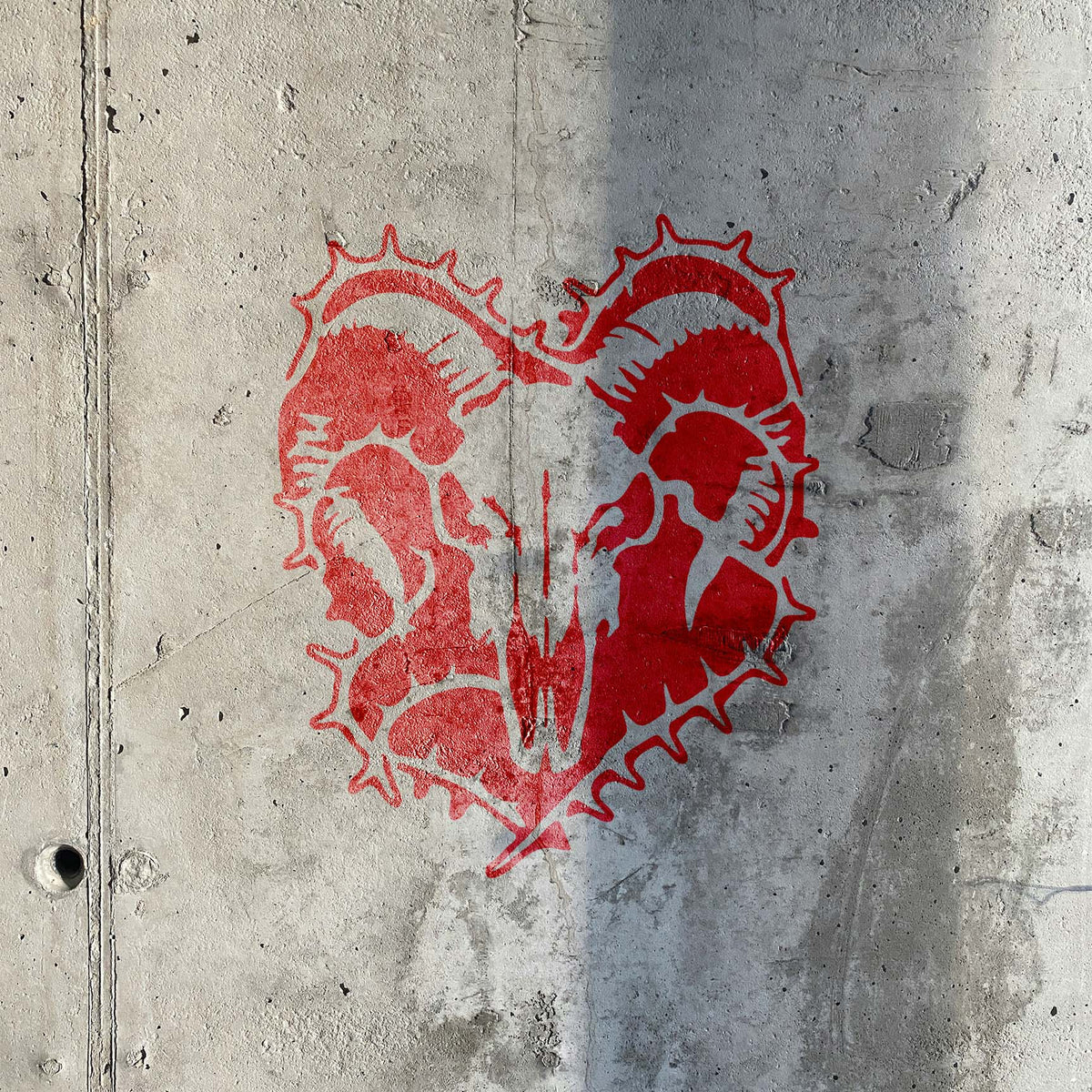 Ram Skull Thorn Wreath Stencil painted red across a raw concrete wall with a weathered finish