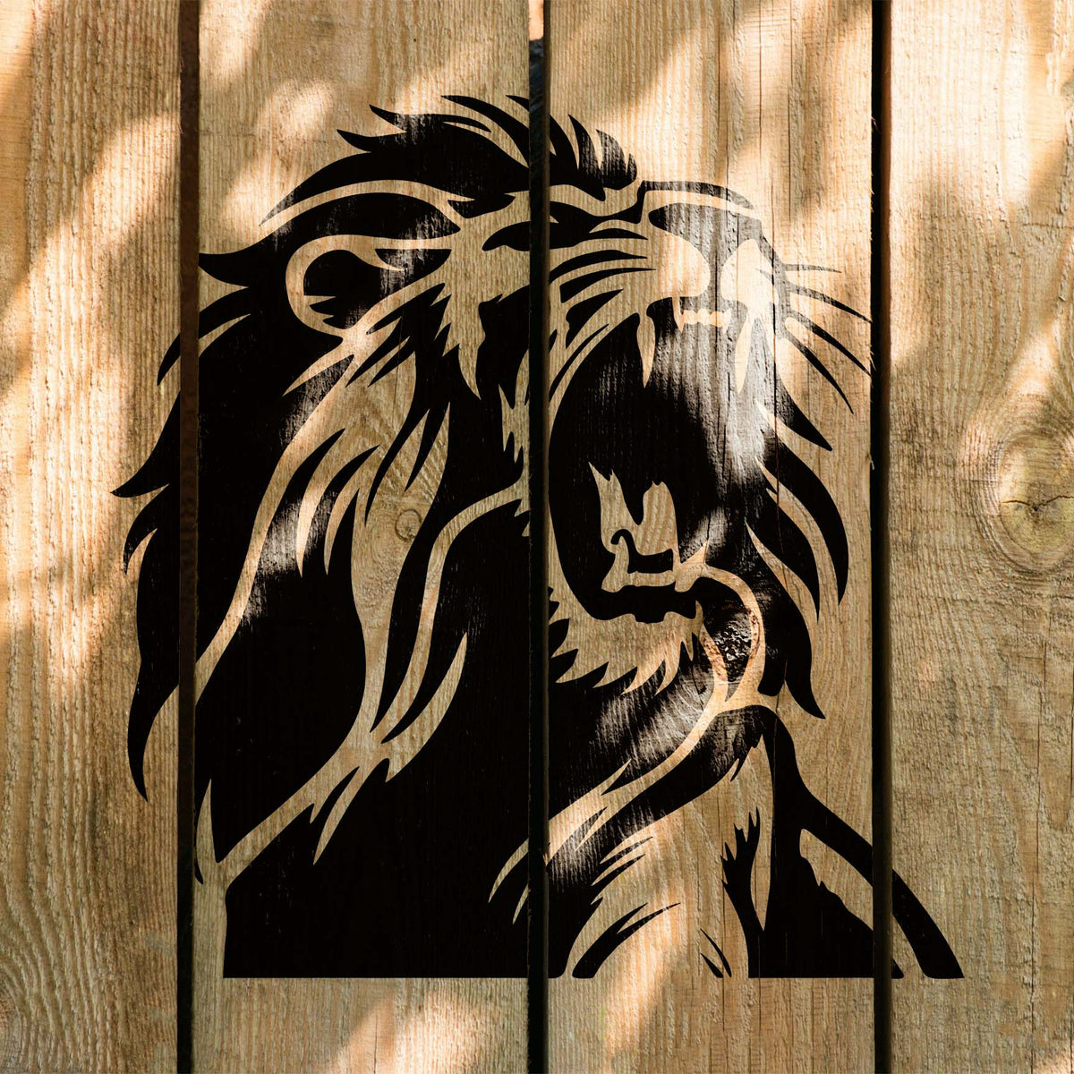 Bold black Roaring Lion Head Stencil displays an open-mouthed lion across rustic wood planks.