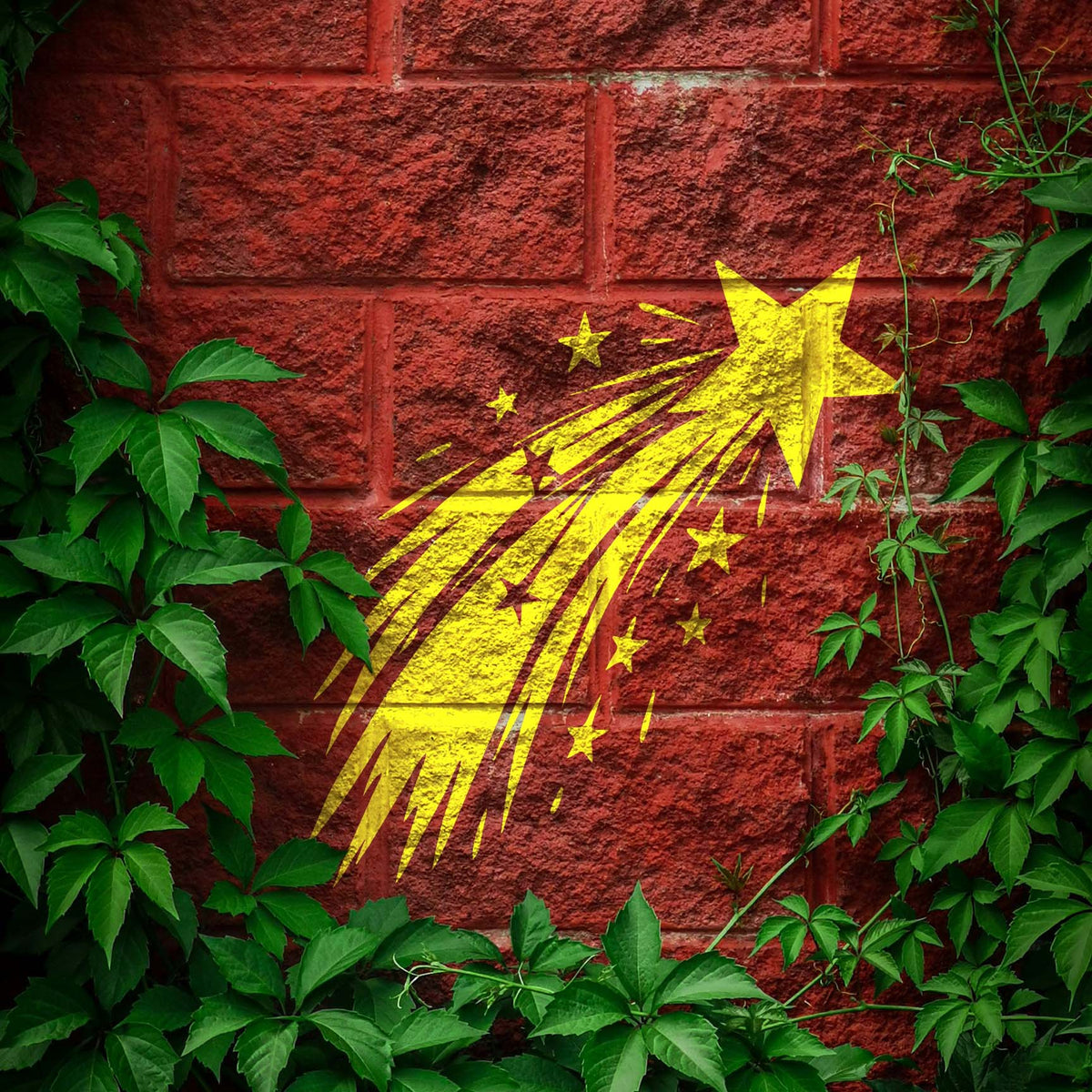 Framed by green vines, the Shooting Star Trail Stencil glows yellow on a red brick wall