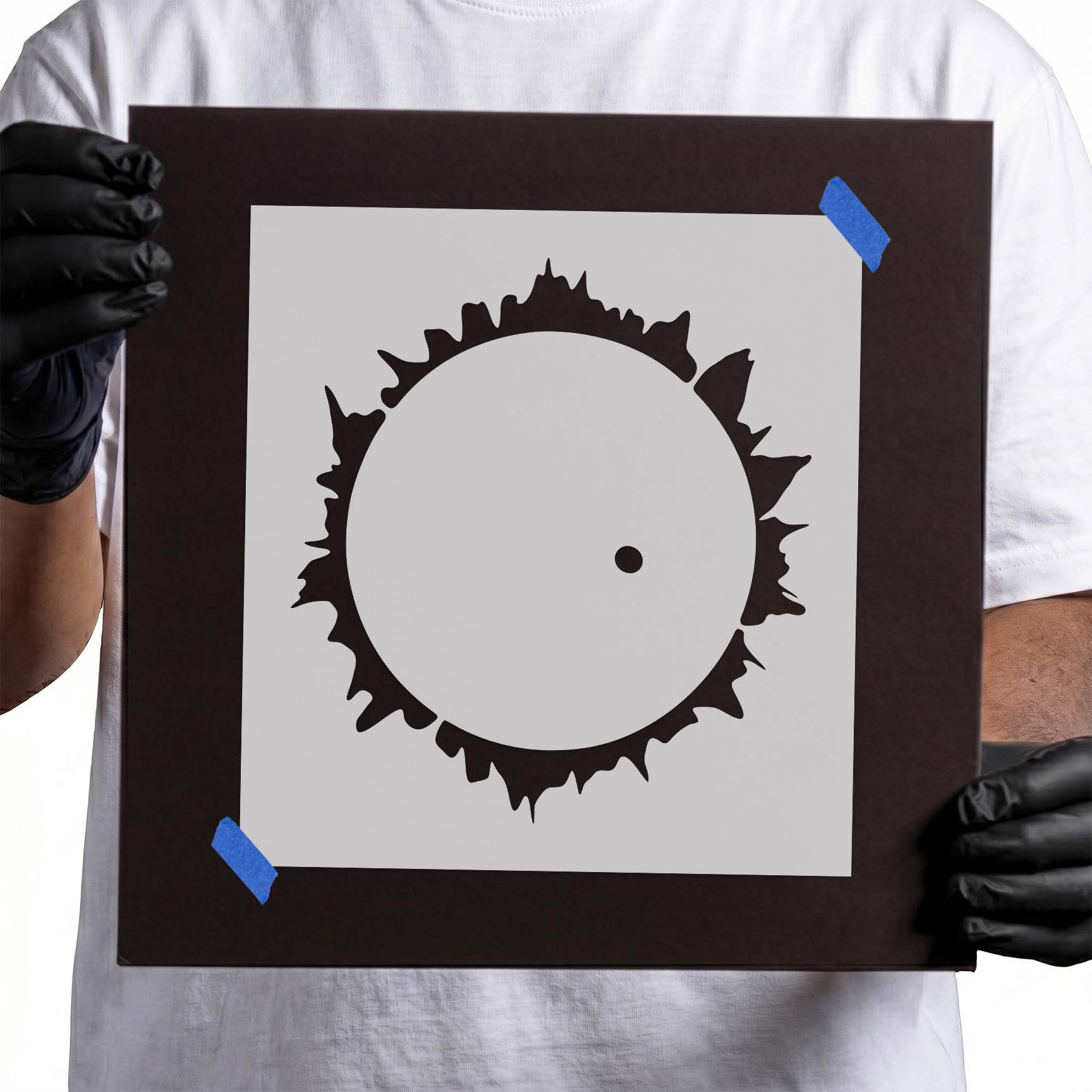Person holding Solar Eclipse Corona Stencil taped to black cardboard