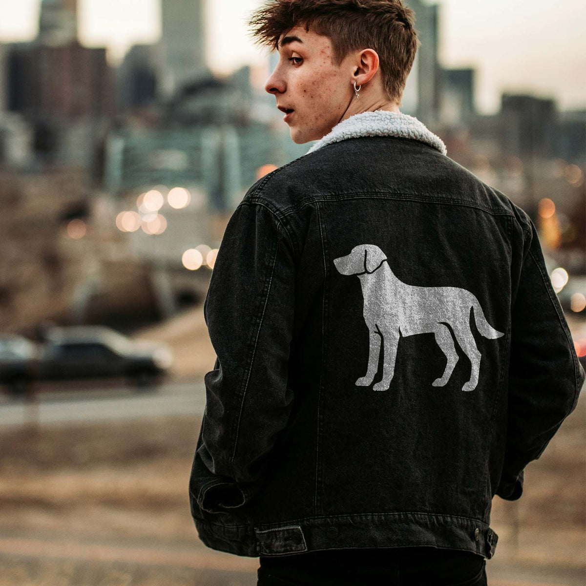 Standing Labrador Retriever Stencil featured on the back of a black jacket in a city scene.