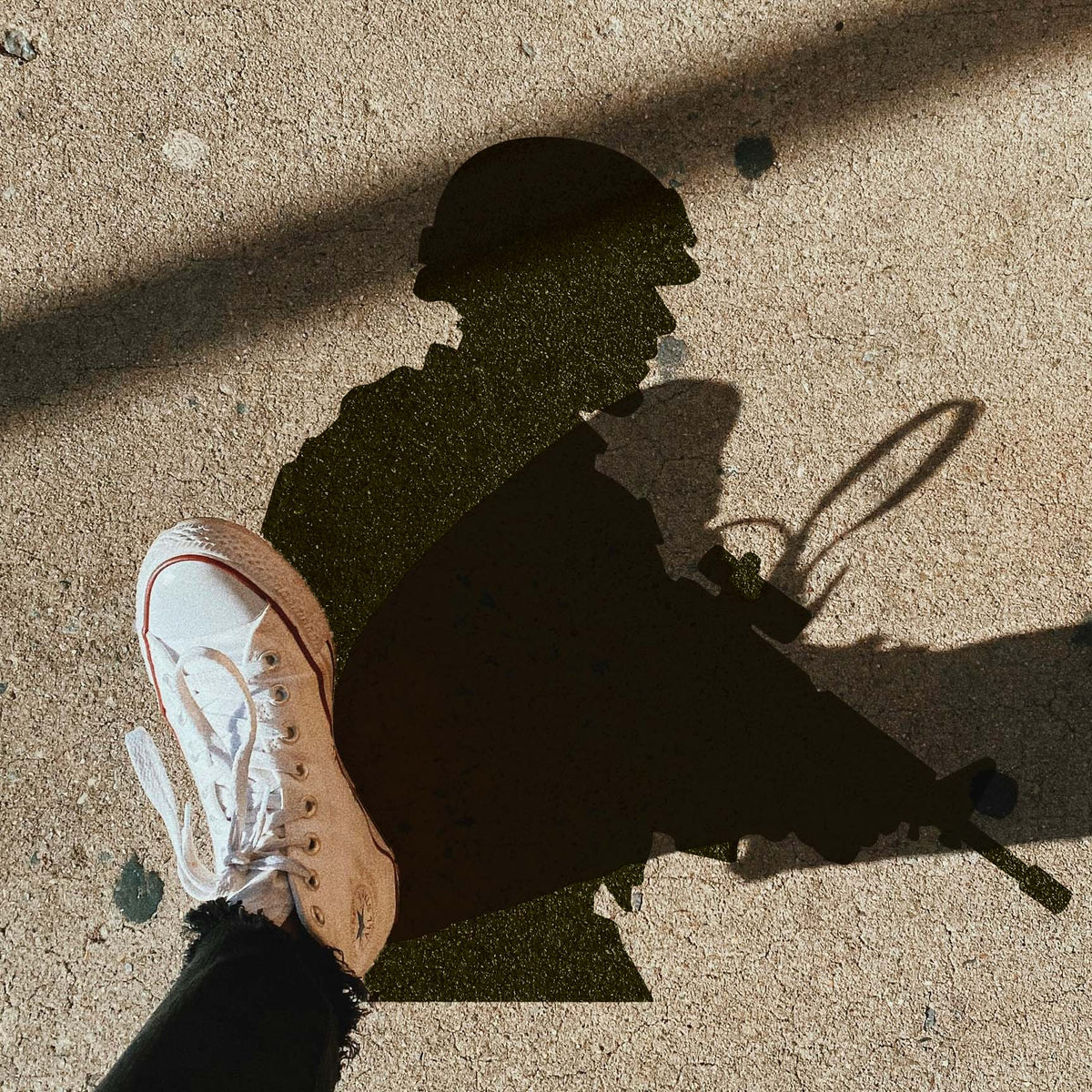 Tactical Soldier Silhouette Stencil shown on pavement beside a white sneaker