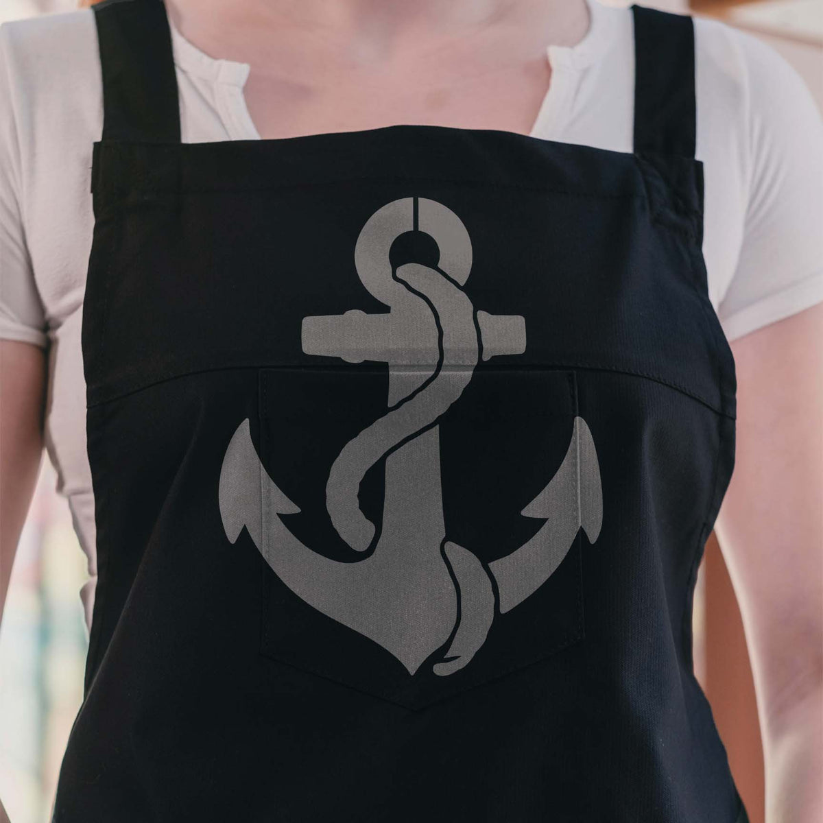 Nautical Anchor with Rope Stencil stands out in gray across the front of a black apron