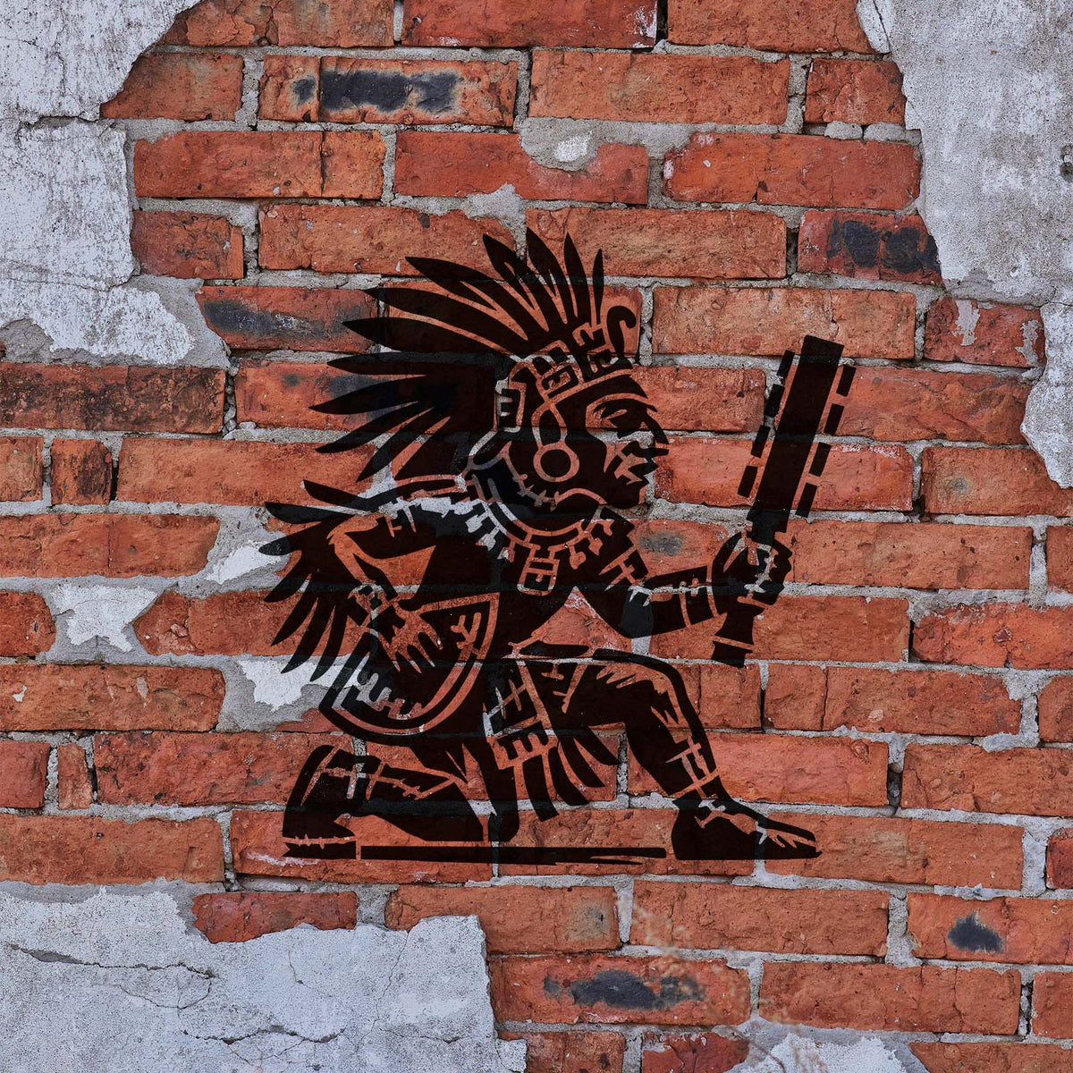 Aztec Warrior Stencil painted dark brown on a weathered red brick wall.