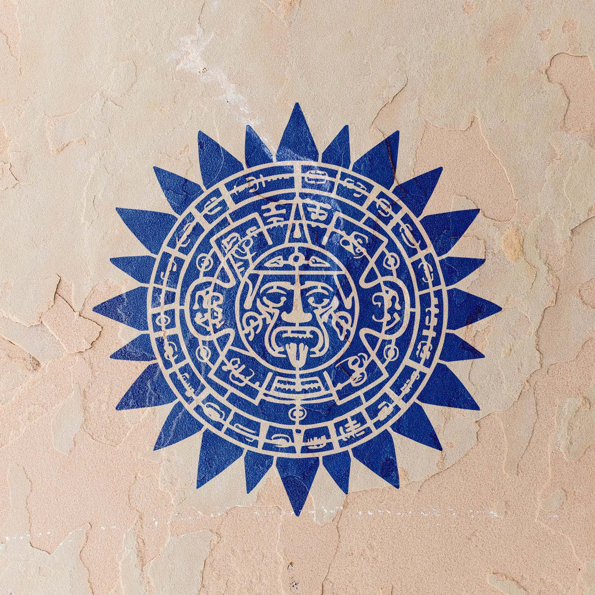 Deep blue Aztec Sun Calendar Stencil displays intricate symbols across a textured stucco wall