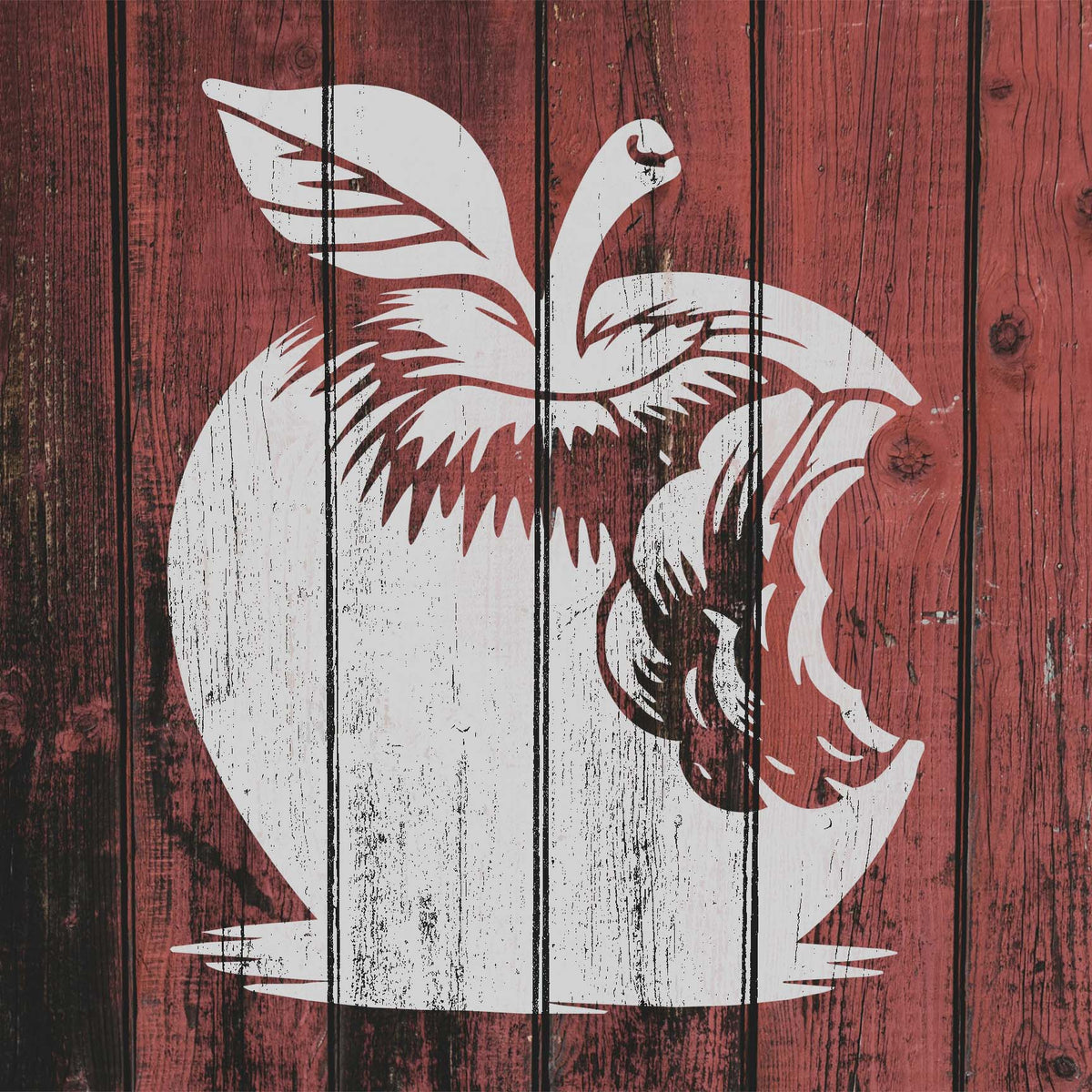 Bitten Apple Stencil in white appears on red wooden boards with a rustic weathered look.