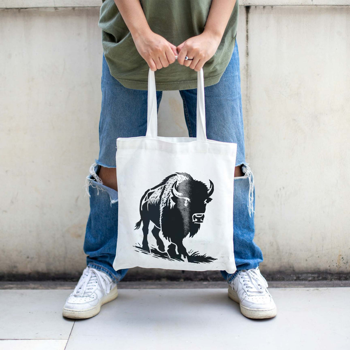 Bold black Buffalo Walking in Plain Stencil features a horned bison on a white canvas tote bag.