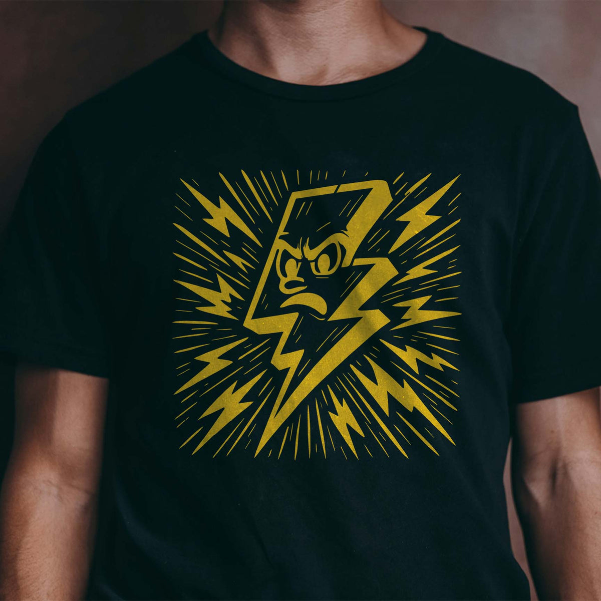 Golden Cartoon Lightning Bolt Stencil crackles across a black T-shirt with an angry face