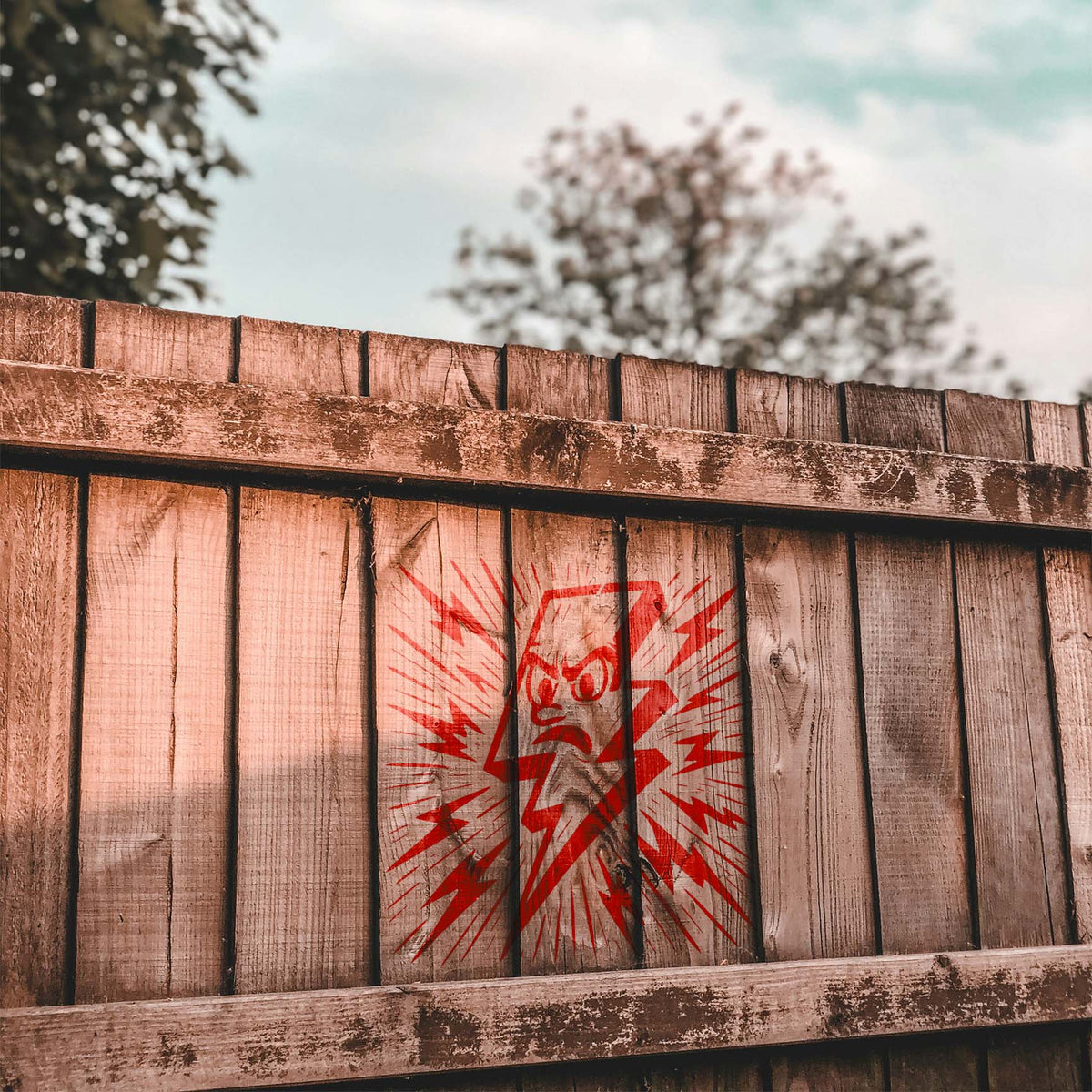 A vivid red Cartoon Lightning Bolt Stencil brings an electric character design to a wood fence
