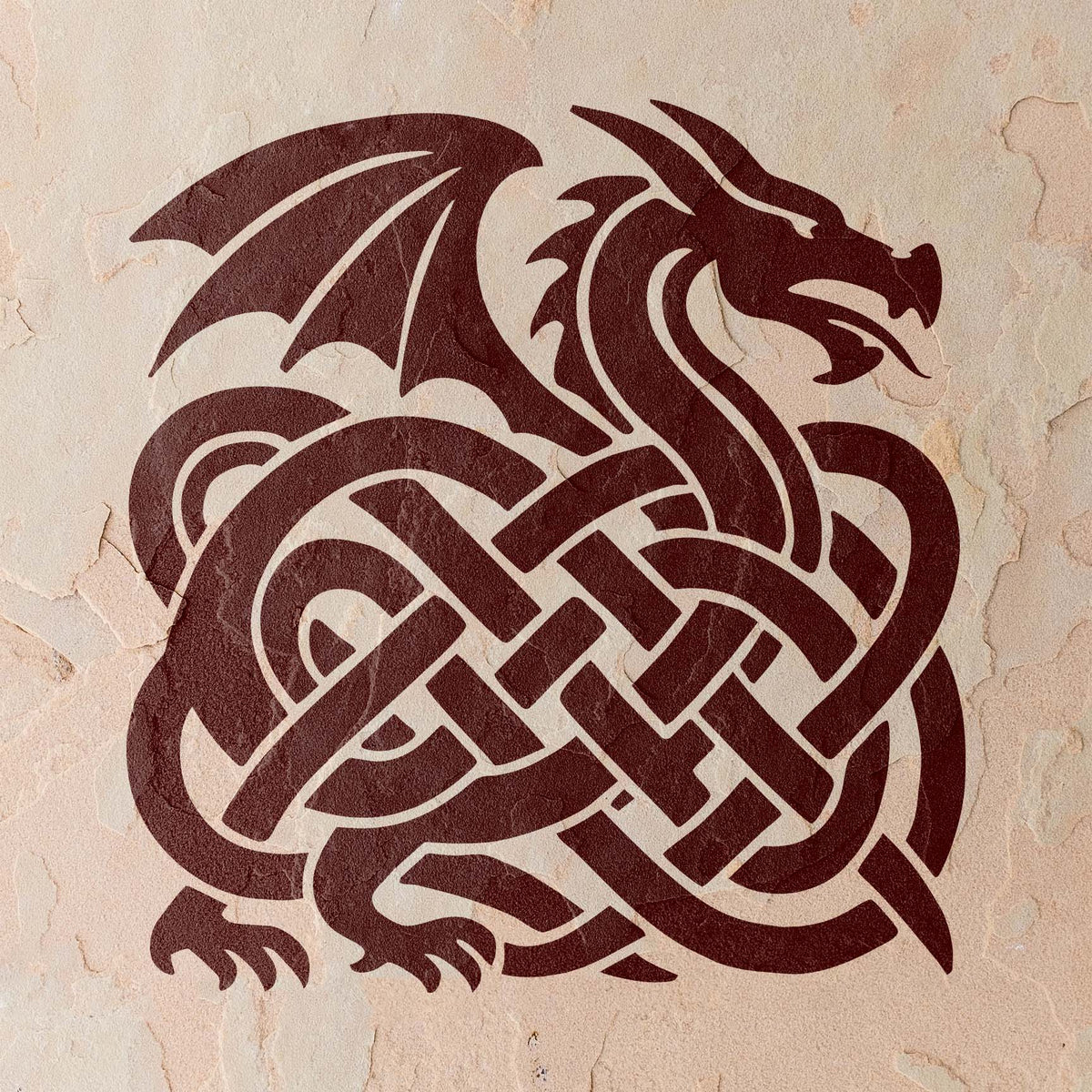 A deep burgundy Celtic Dragon Knot Stencil reveals a fierce winged dragon woven into knots on a beige wall.