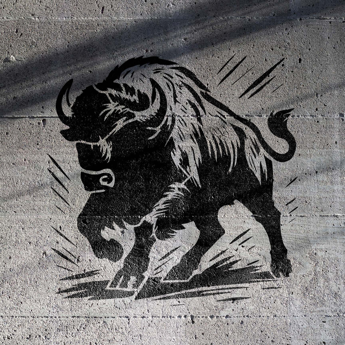 Charging Bison Stencil shows a fierce black bison with raised hooves on a gray concrete wall.