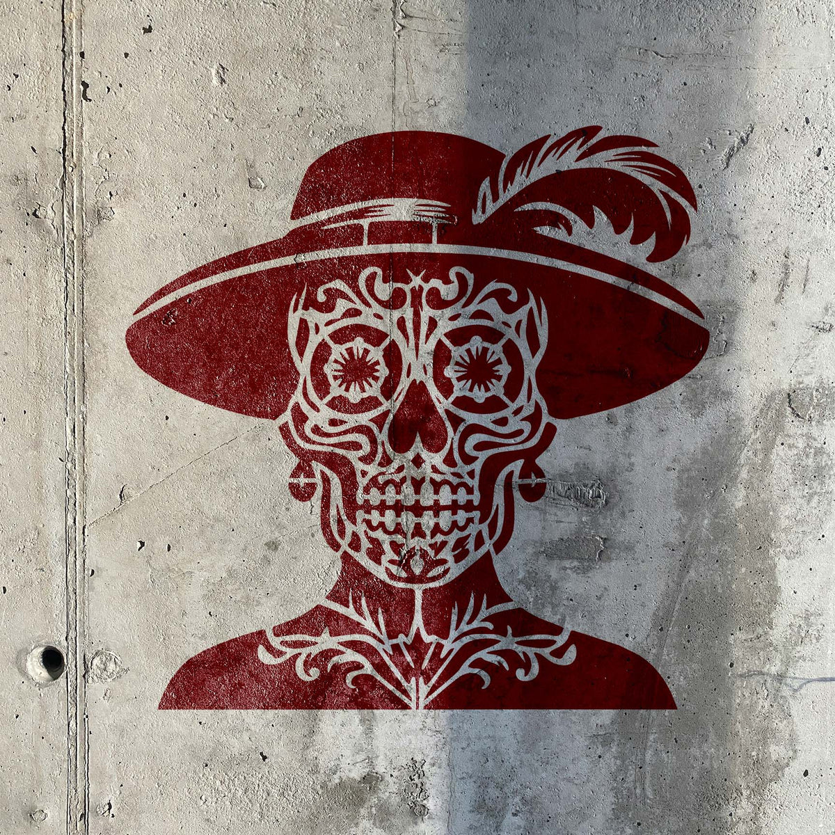 Classic Catrina Sugar Skull Stencil in deep red decorates a weathered concrete wall.