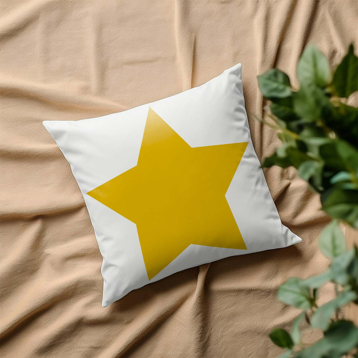 A cheerful yellow Classic Five-Point Star Stencil brightens a white pillow resting on soft beige fabric.