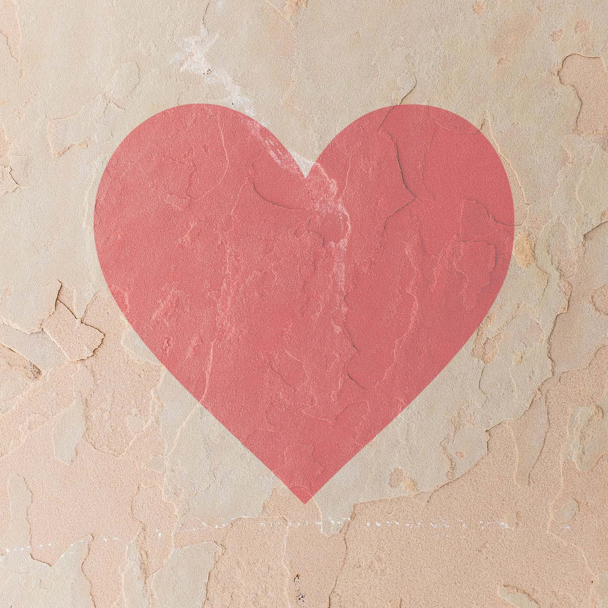 Soft pink meets rustic charm as the Classic Heart Stencil decorates a weathered beige stucco wall.