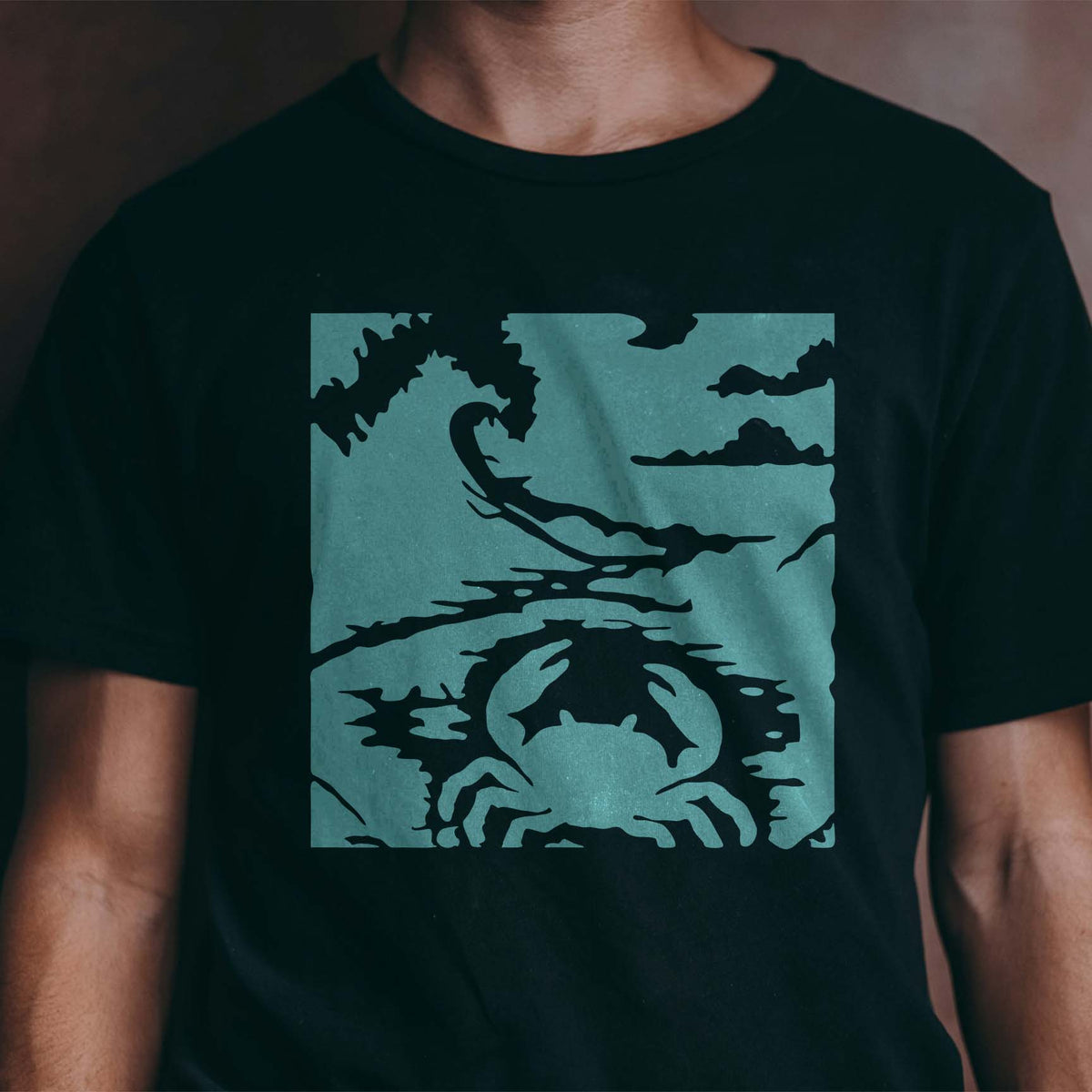Seashore Crab Stencil adds a coastal crab and ocean wave design to a black T-shirt.