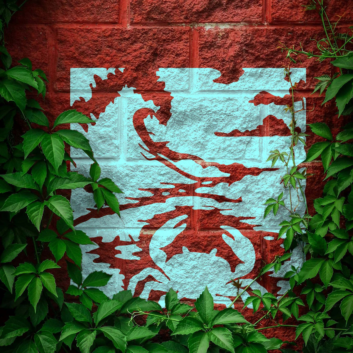 A leafy brick wall features the Seashore Crab Stencil with a bold crab and rolling waves.