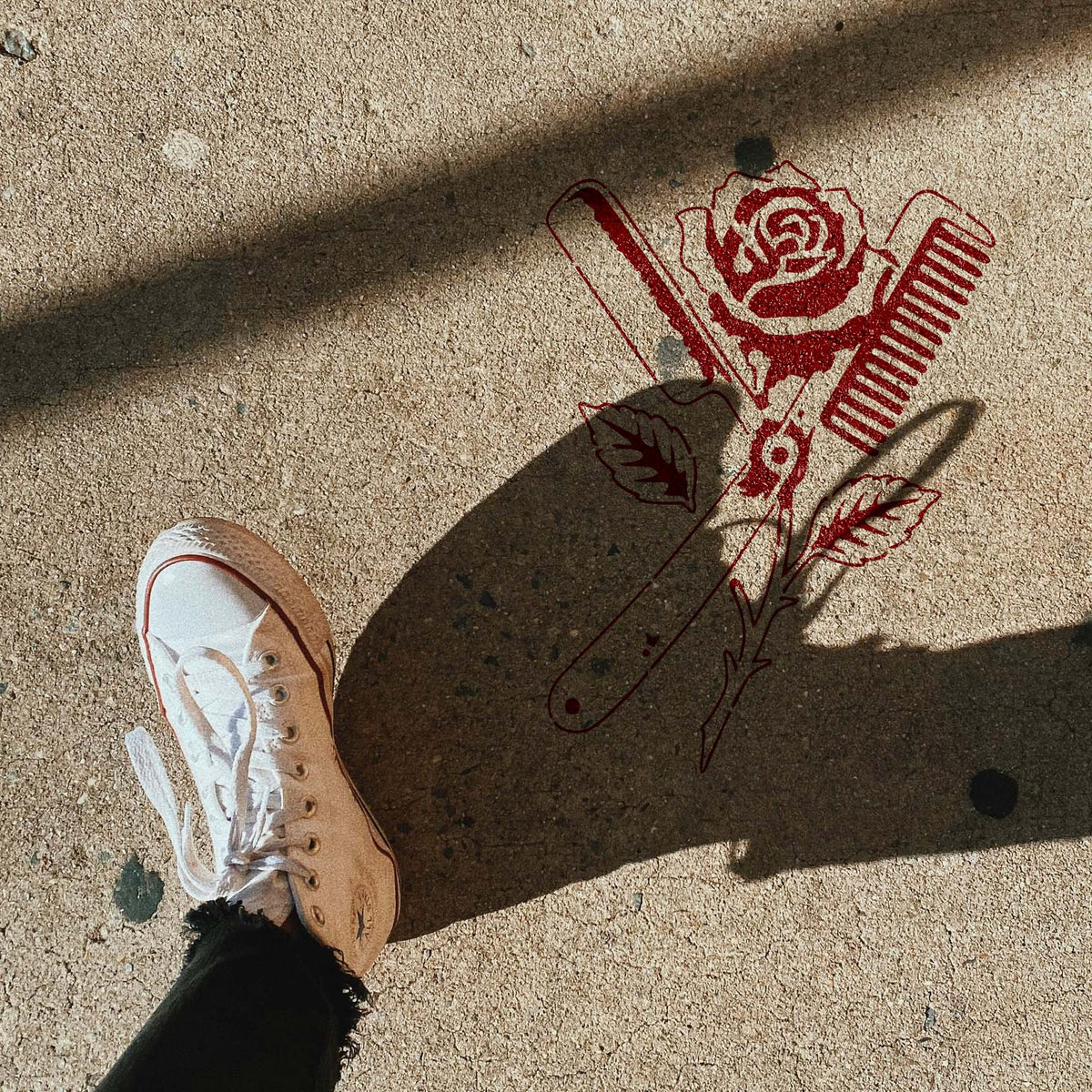 Barber Straight Razor Rose stencil painted red on concrete sidewalk
