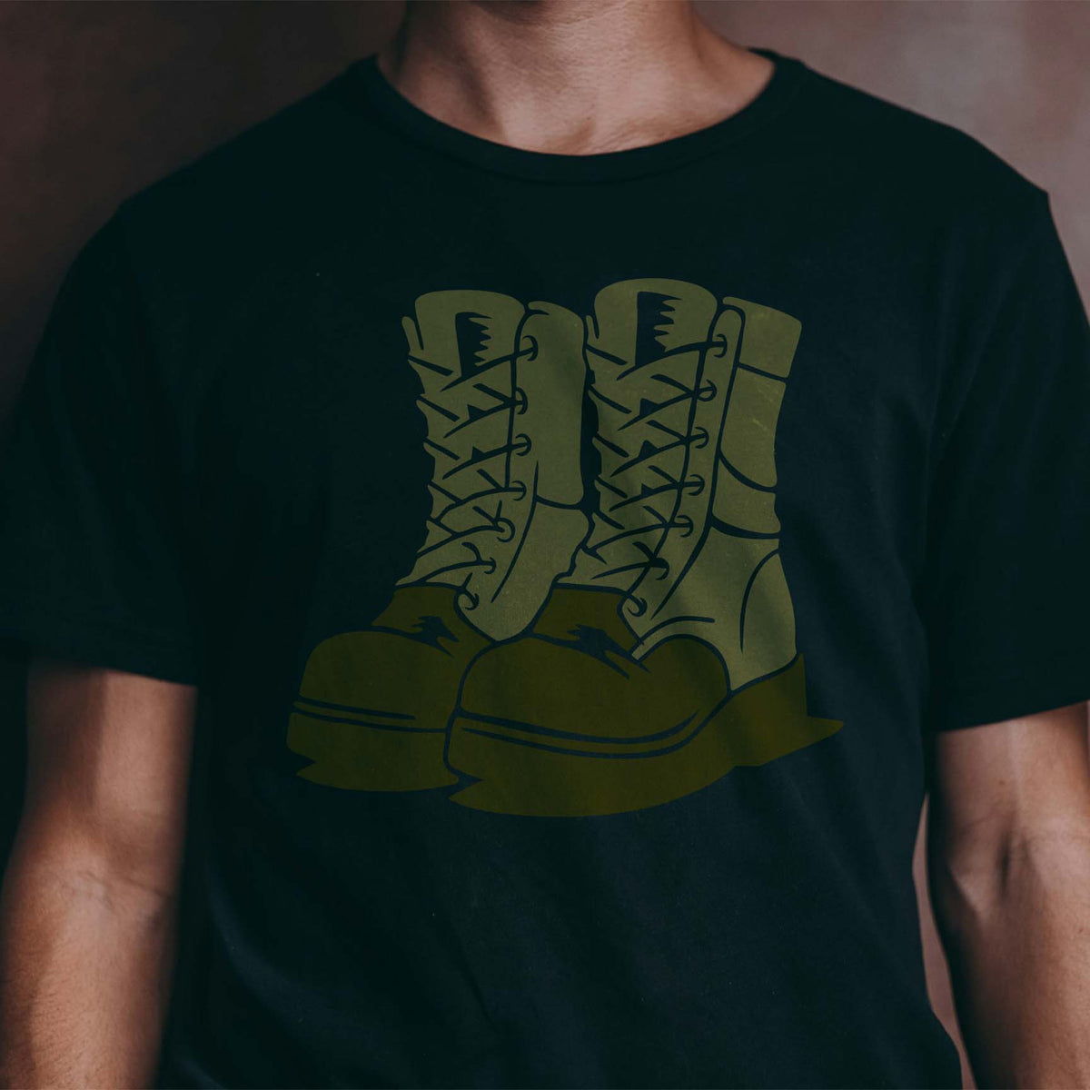 Combat Military Boots Stencil in olive green printed on a black T-shirt.