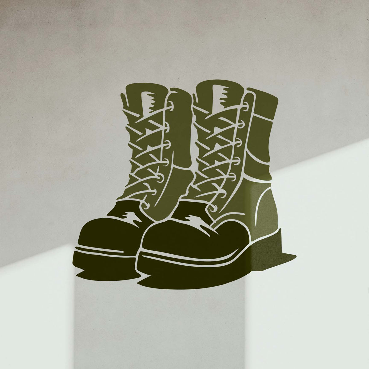 Combat Military Boots Stencil in olive green displayed on a light wall with shadows.