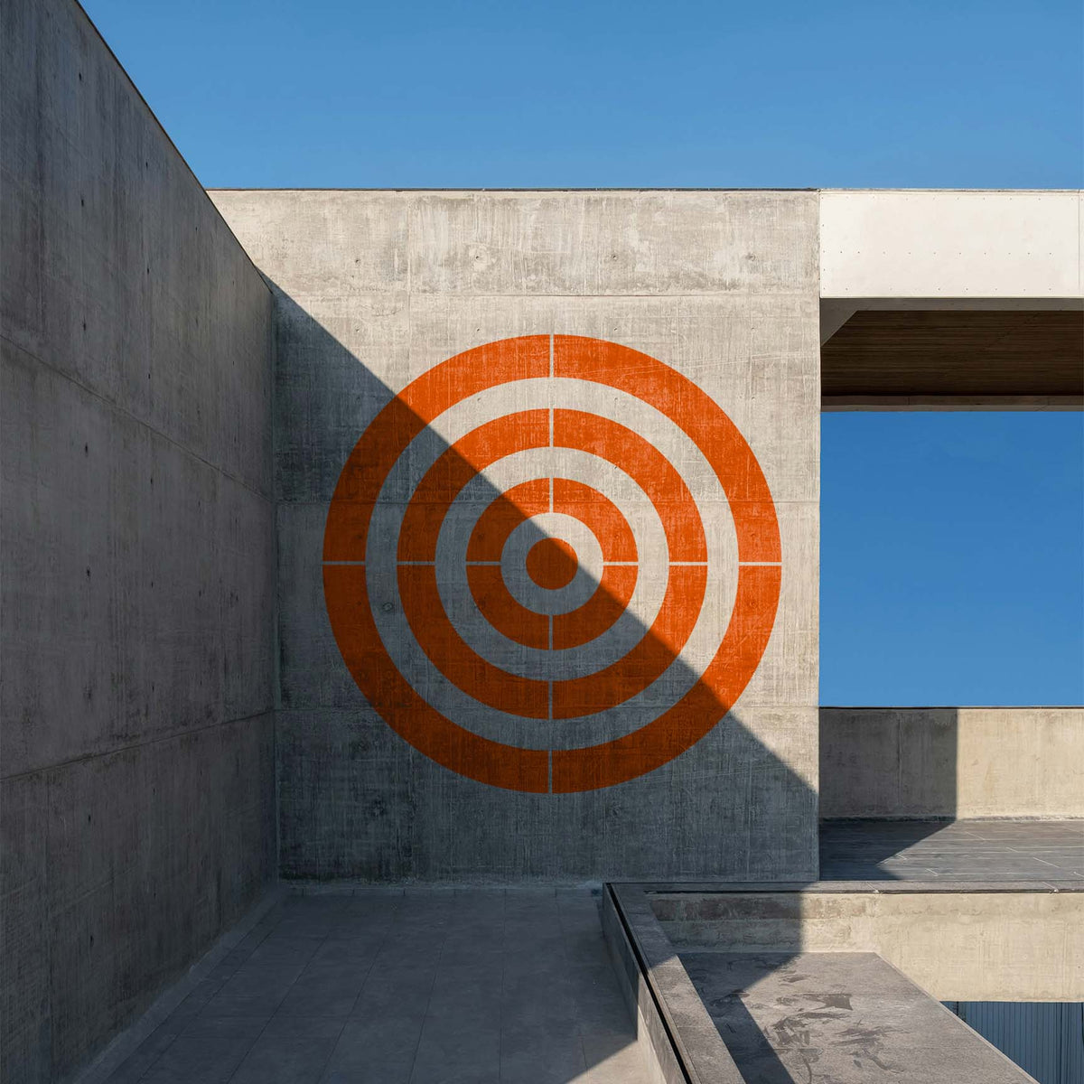Oversized Concentric Circle Target Stencil brings orange rings to a modern concrete wal