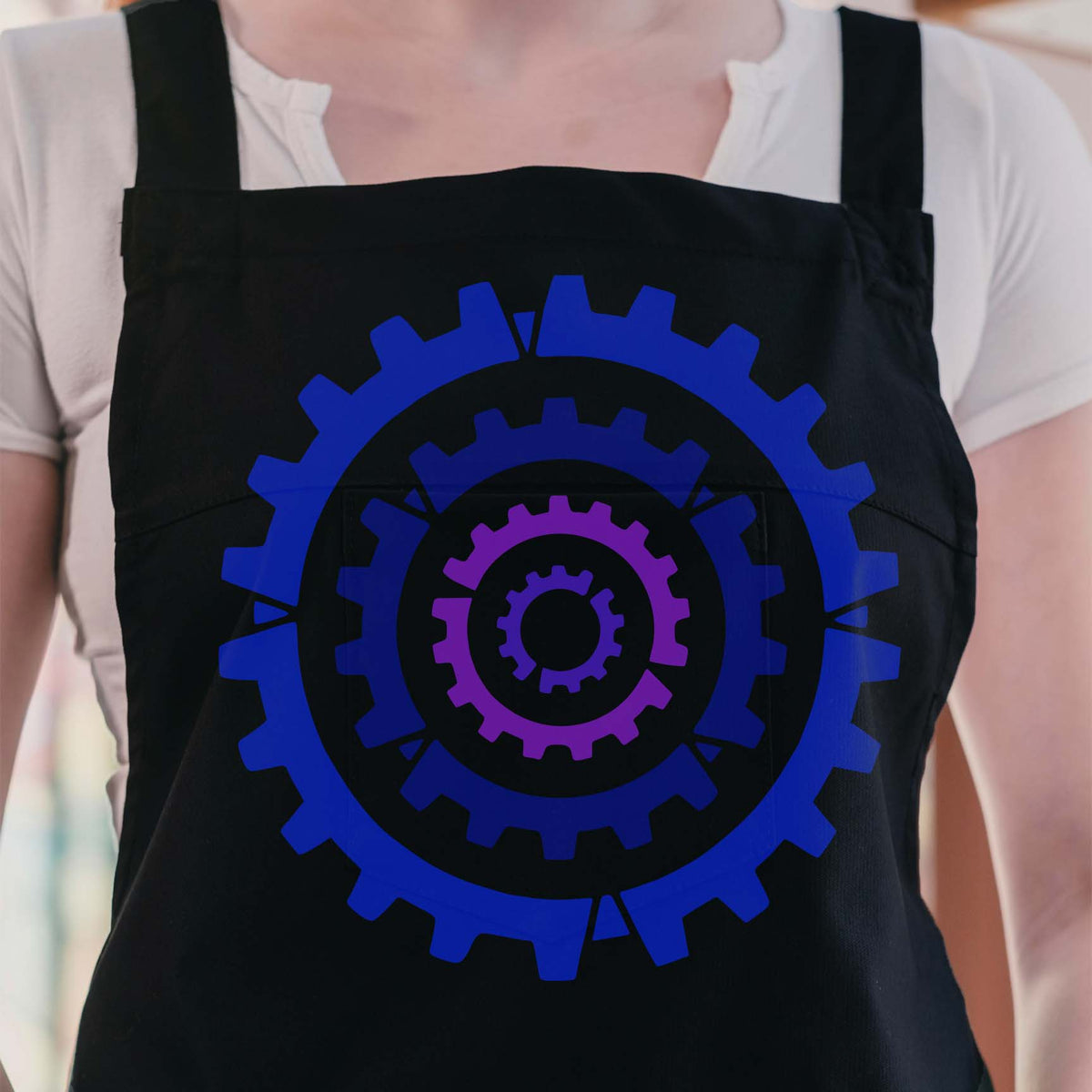 Concentric Cogs stencil with layered blue and purple gear design on black apron