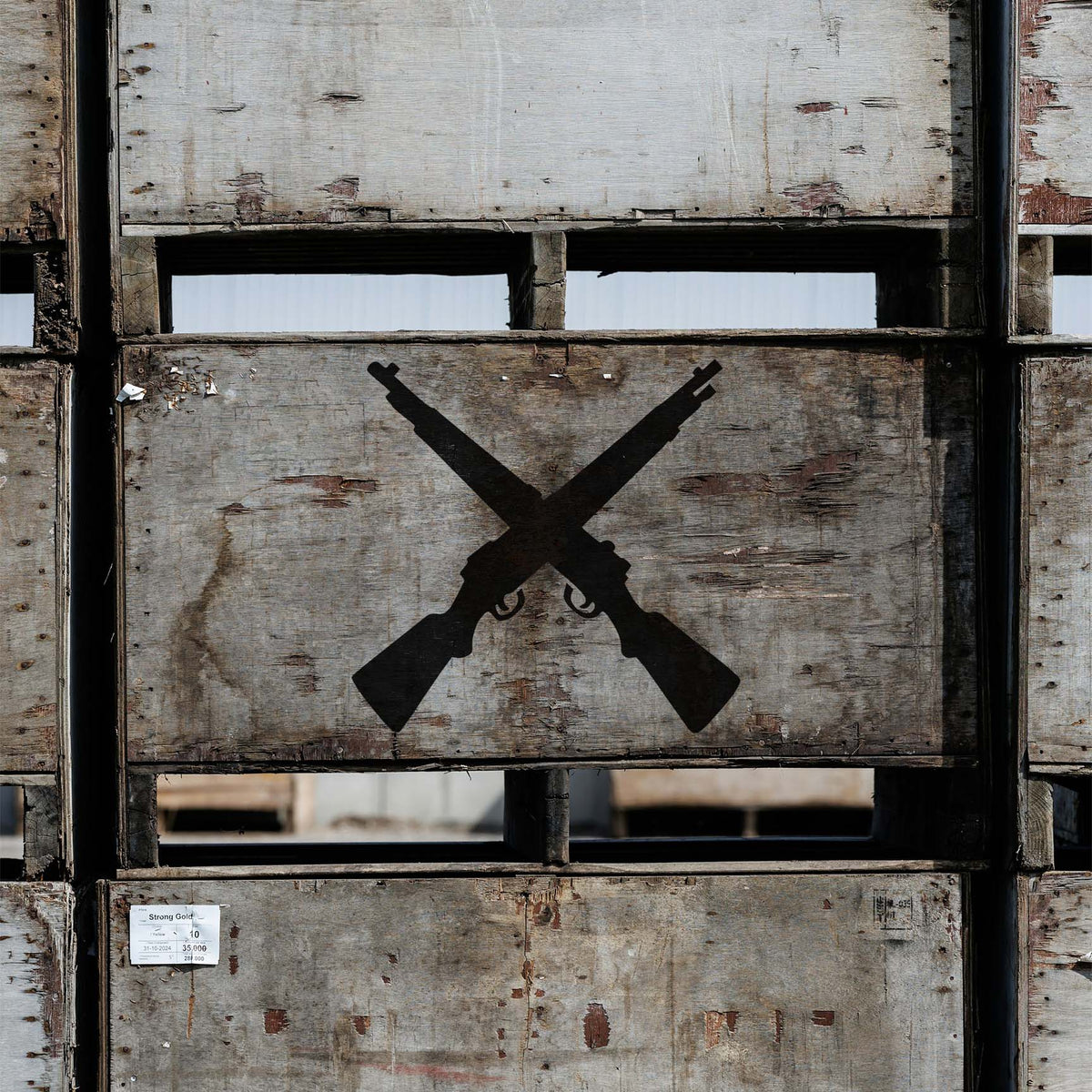 Crossed Rifles Silhouette stencil displayed on rustic wooden crates