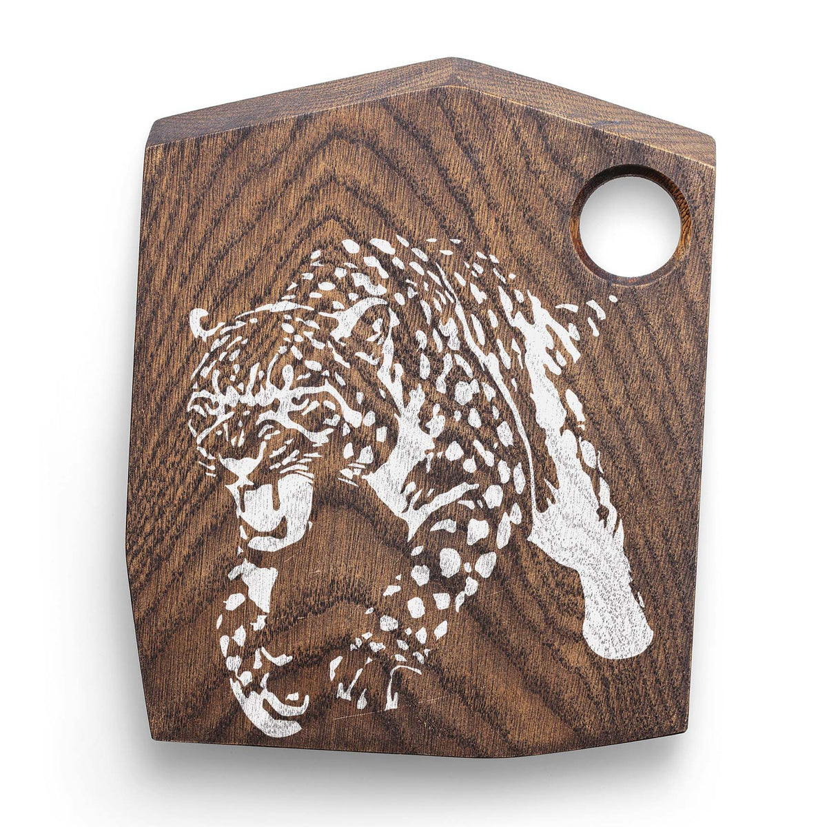 Crouching Cheetah stencil painted white on a dark wooden cutting board