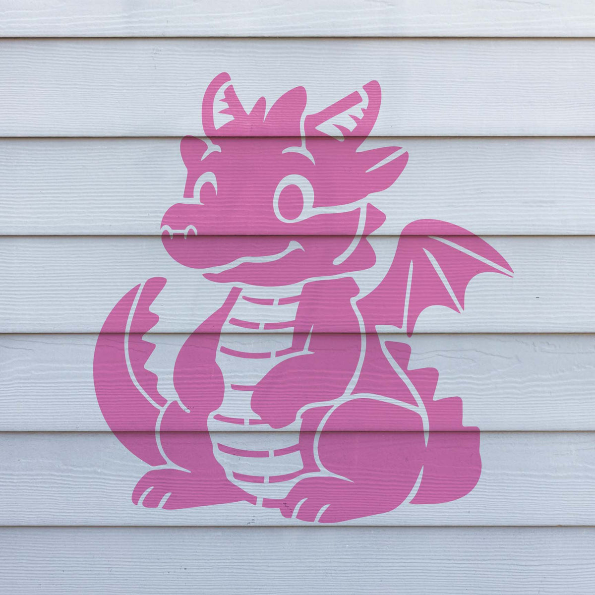 With big eyes and a friendly grin, the pink Cute Cartoon Dragon Stencil stands out on white horizontal siding.