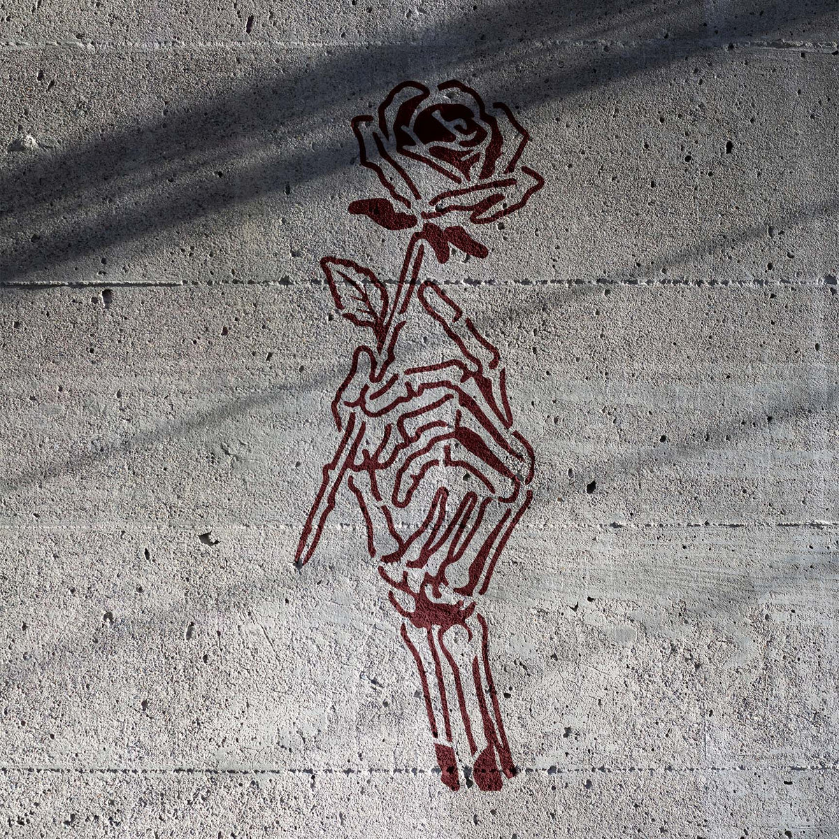 Death Bouquet Skeleton Hand Stencil paints skeletal fingers gripping a rose on raw concrete