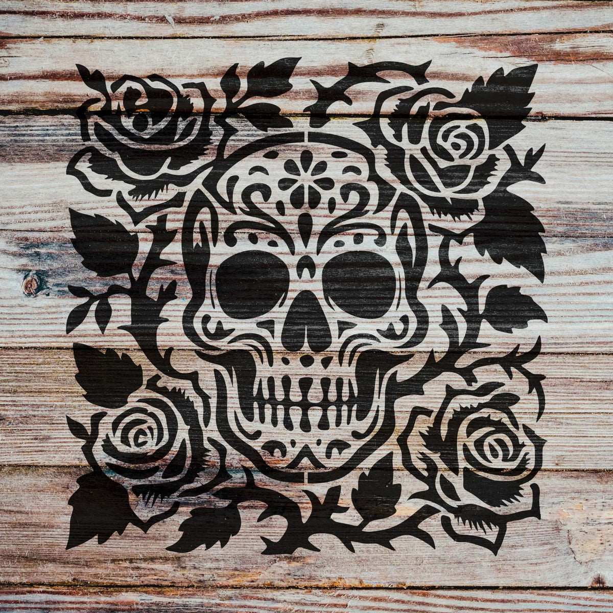 Rustic wood displays the Decorative Sugar Skull and Roses Stencil with an ornate floral skull design