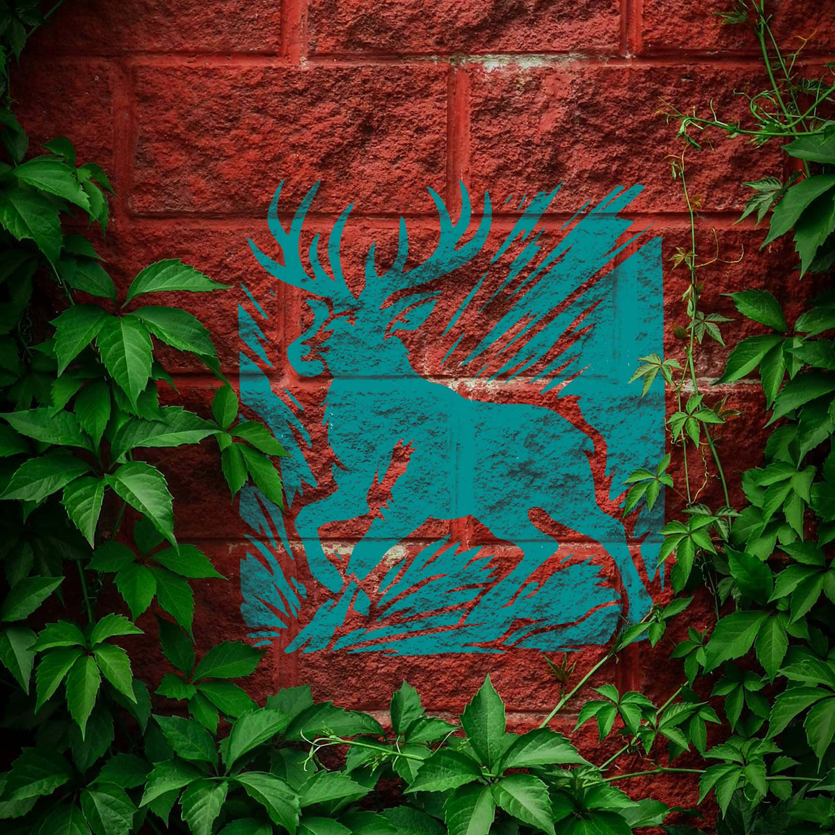 Deer With Antlers Stencil painted in teal on red brick wall