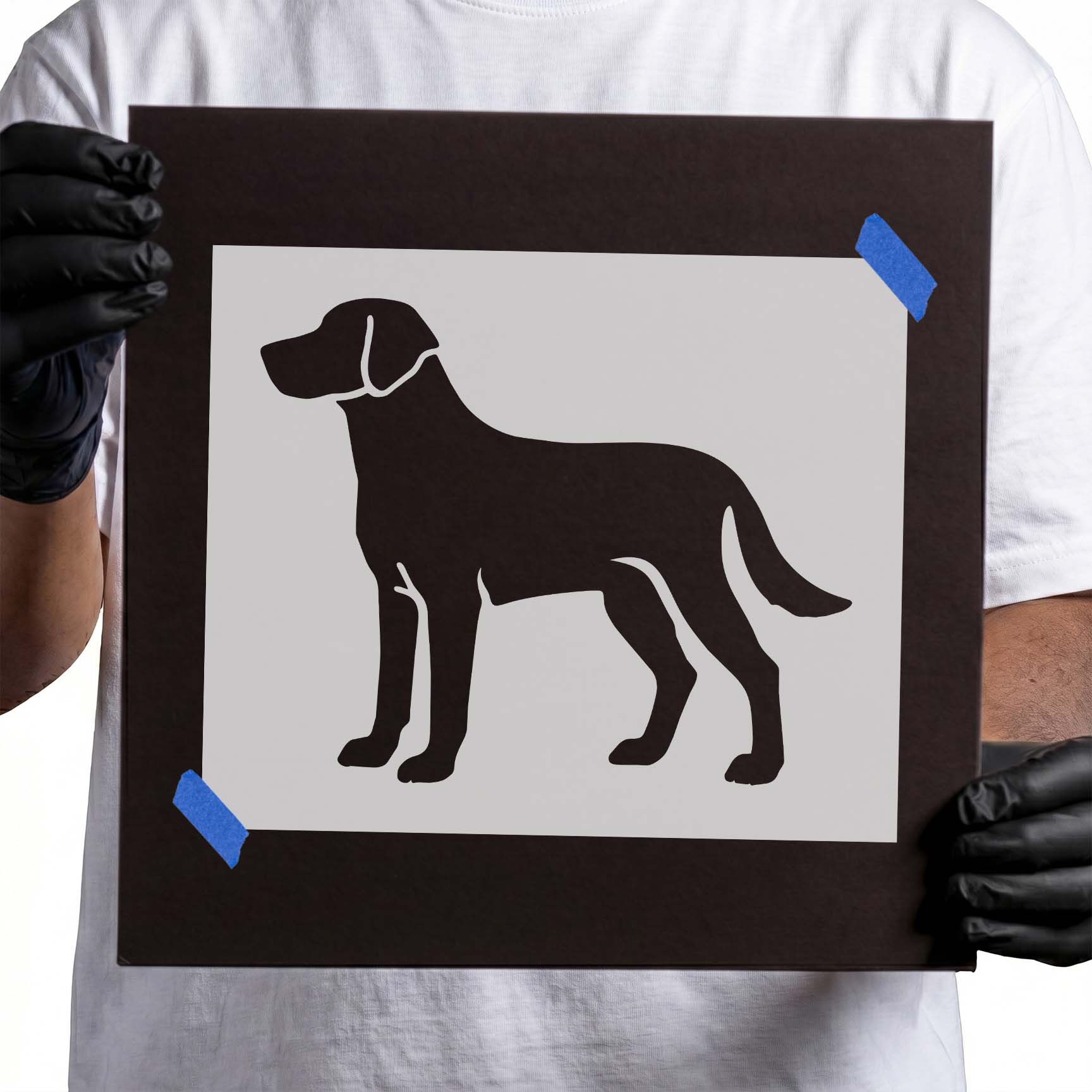 Person holding Standing Labrador Retriever Stencil taped to black cardboard