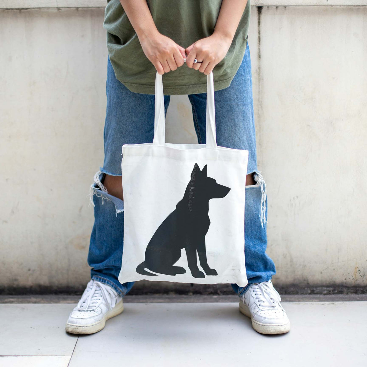 A crisp Sitting Dog Silhouette Stencil decorates a white tote bag with a black canine profile