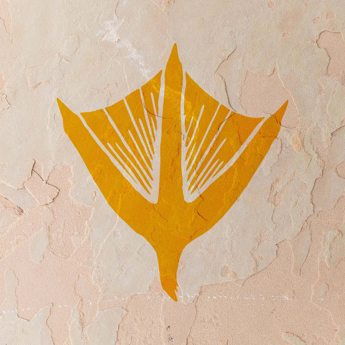Against a weathered beige wall, the golden Duck Track Stencil reveals three pointed toes joined by webbing.