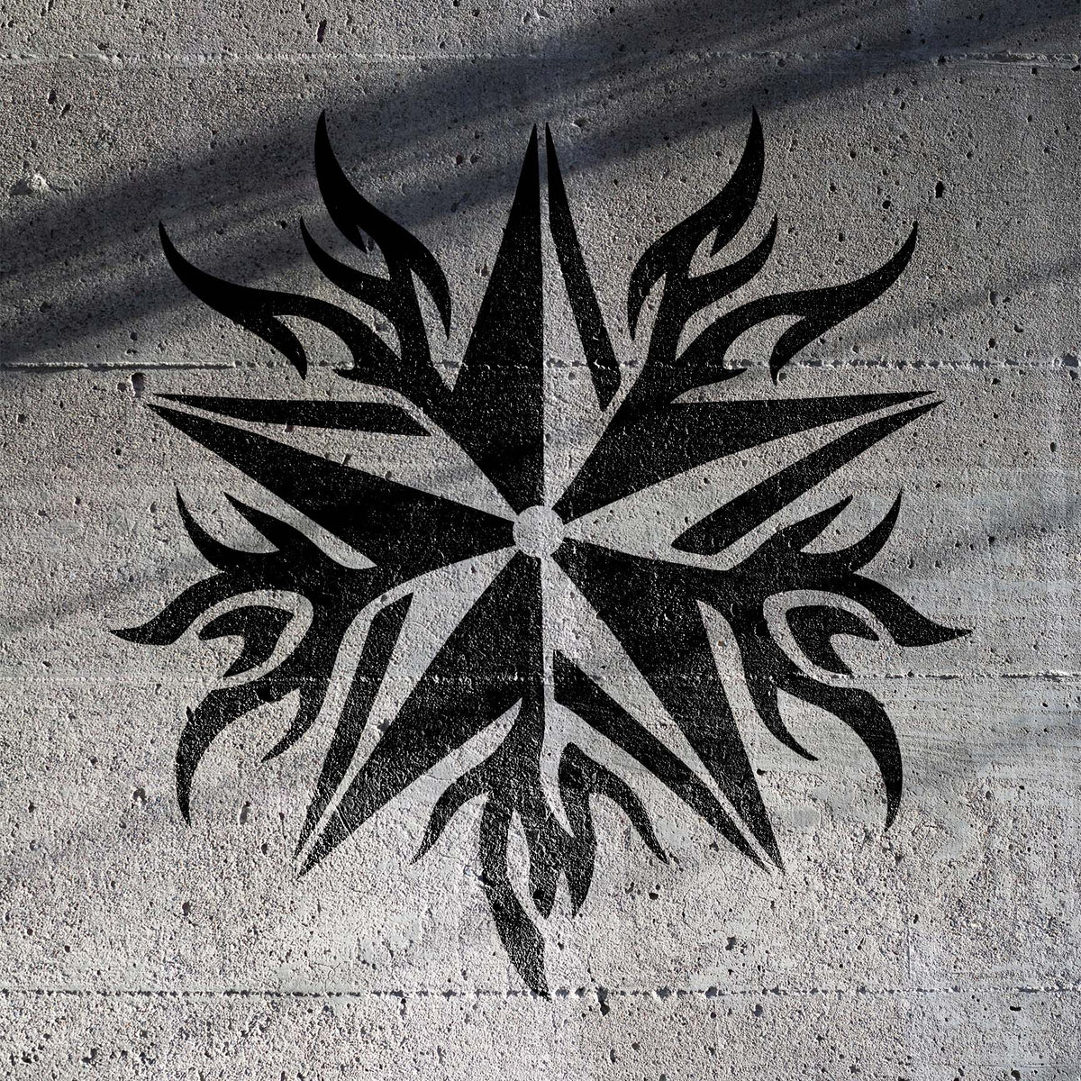 Bold black Flame Tribal Star Stencil spreads sharp flame points across textured concrete