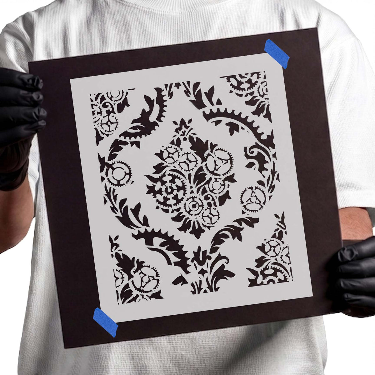 Floral gear stencil with interlocking cogwheels, curling leaves, and ornate flourishes