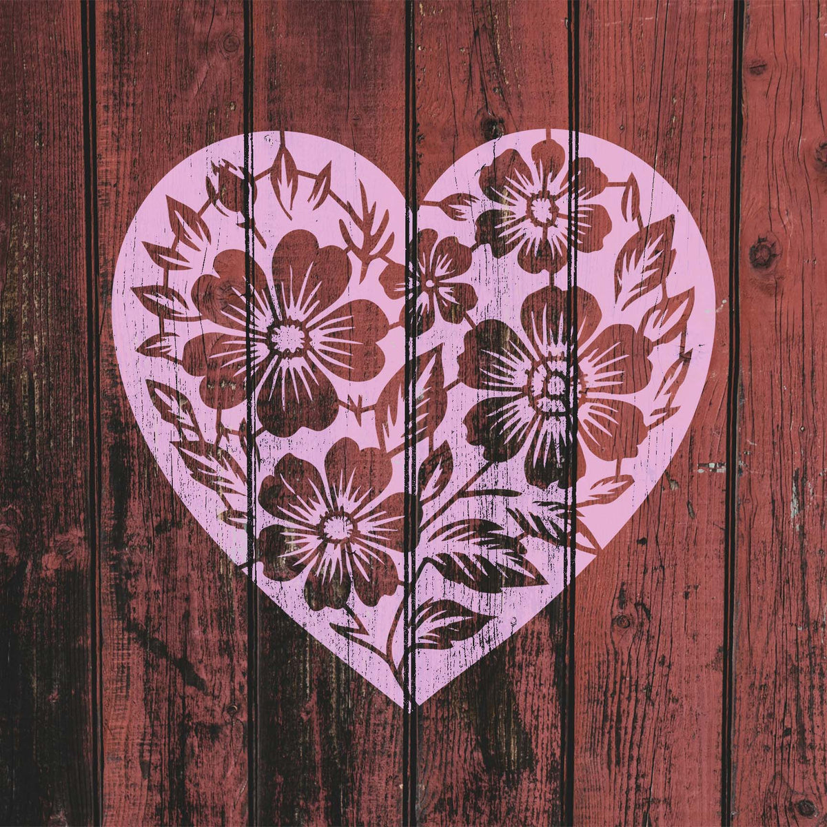 Rustic red wood showcases the Floral Heart Silhouette Stencil filled with layered botanical details
