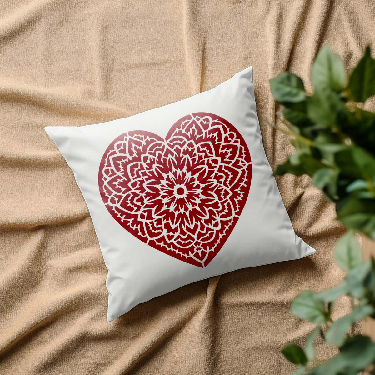 Floral Mandala Heart Stencil decorates a white pillow with an intricate red floral heart design