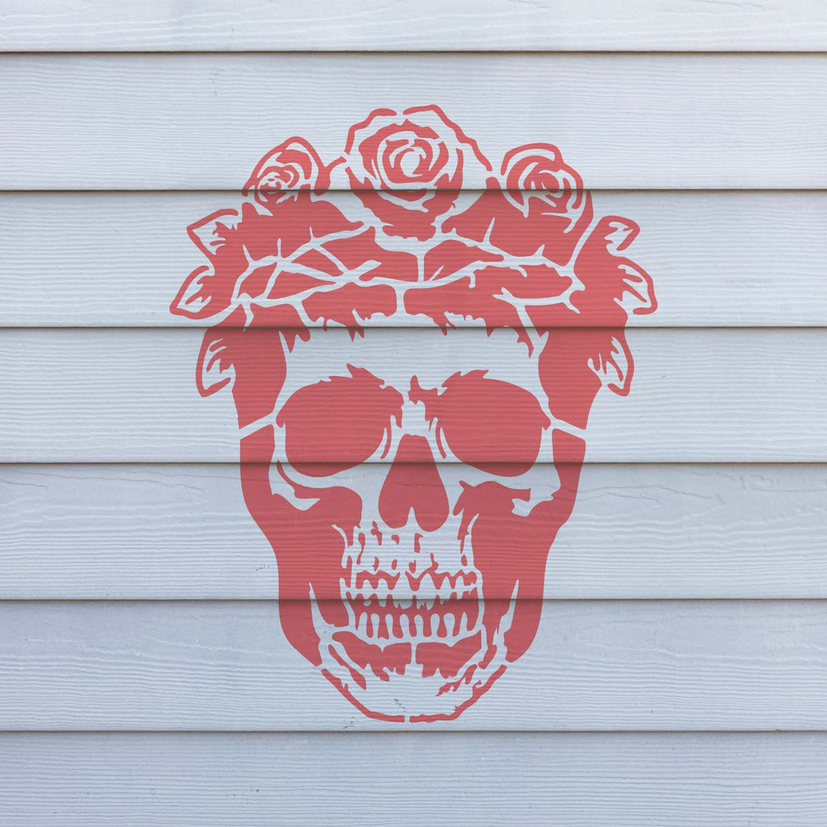 A coral Floral Skull with Rose Crown Stencil stands out across white exterior wall siding