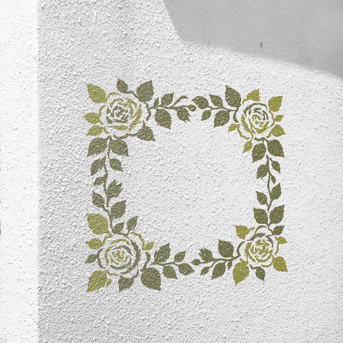 Floral Wedding Border stencil with leafy green roses on a textured white wall