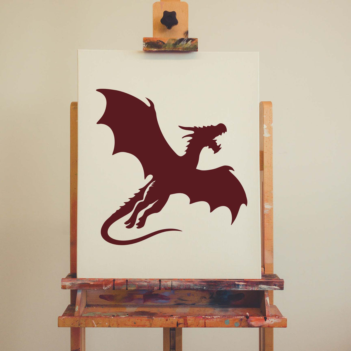 Bold Flying Dragon Silhouette Stencil painted in burgundy across a white artist canvas
